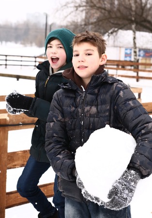 happy friends preteen boys in snow city park have funの写真素材