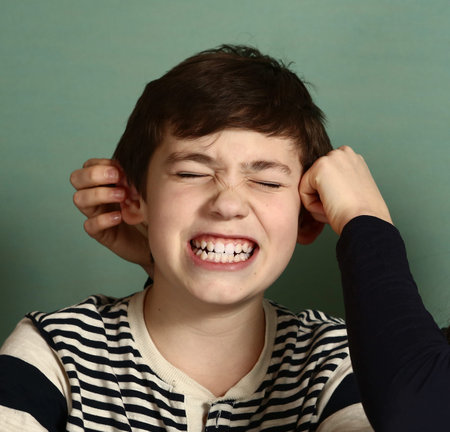 teenager sister pull her brother boy ears because of the lost bet