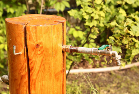 log water tape outlet on the summer sunny garden backgroundの写真素材