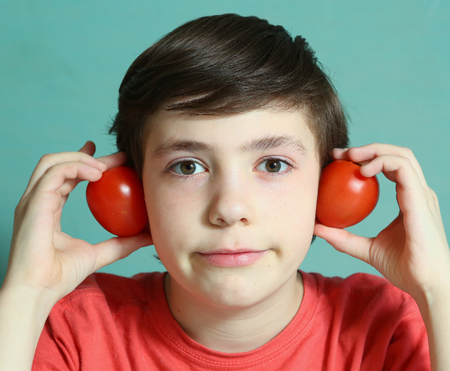 preteen boy with tomato ears close up portraitの写真素材