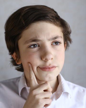preteen kid boy thinking the idea over close up expressive portraitの写真素材