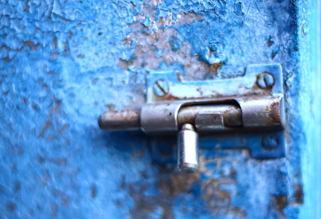 old vintage latch lock on blue shabby cracked painted door