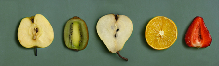 cut fruit - orange, pear, strawberry, kiwi, apple on kitchen board close up photoの写真素材
