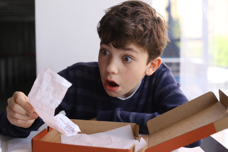 teenager boy shocked expression after see bill for pizza in fast food restaurantの写真素材