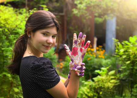 teenager girl in polka dot dress and garden gloves on summer green country backgroundの写真素材