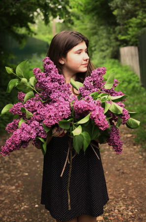 teenager girl with lilac violet flowers close up photoの写真素材