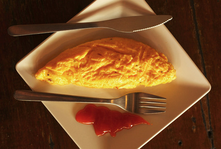 breakfast omlette close up photo on square plate with fork close up photoの写真素材