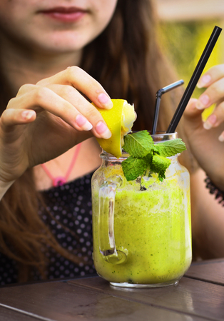 fresh lemon shoothie in jar with straw on wooden tableの写真素材