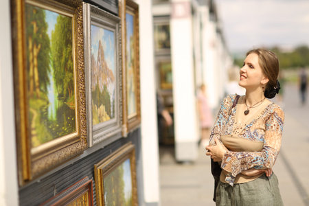 Moscow, Russia, August 12, 2019: Inidentified women walk on street on open air painting vernissage...