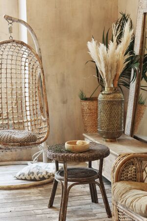 bedroom interior designed in oriental east style with ikebana in vase mirror swing and wicker furnitureの写真素材