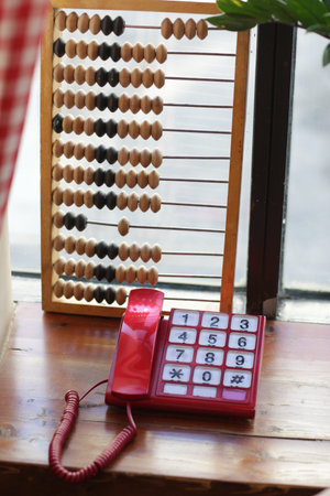 wooden abacus calculating frame and telephone on window background