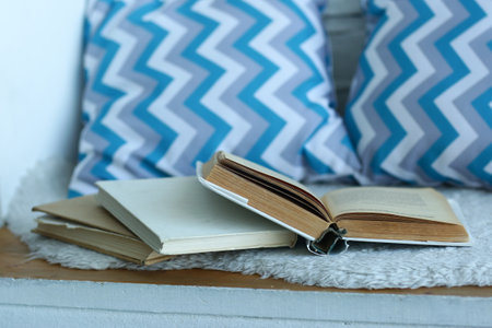 opened book with blue pattern pillows in the bedroom closeup photoの写真素材