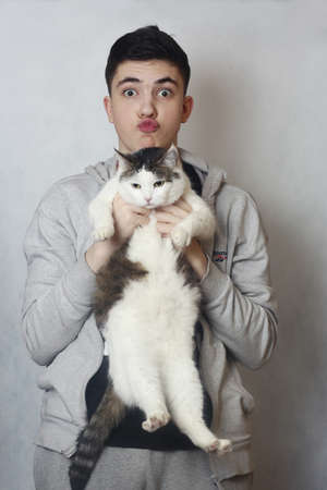 teenager boy cuddle with cat closeup photo isolated on whiteの写真素材