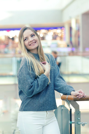 happy smiling blond girl close up portrait on shopping mall background
