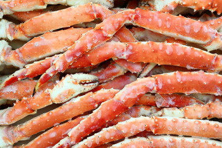 frosted Alaska king crab legs closeup photo on white table backgroundの写真素材