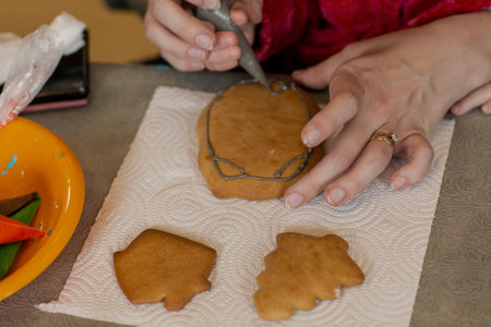 ginger bread cookies decorating with human hand holding glaze coneの写真素材