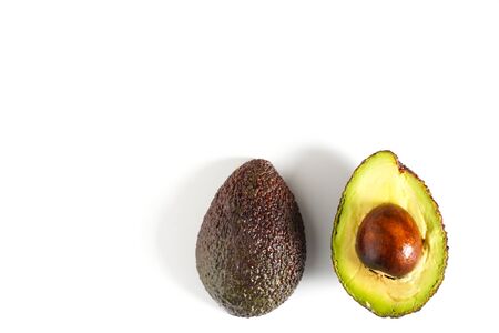 An avocado sliced in half to reveal the core against a plain whit backgroundの写真素材