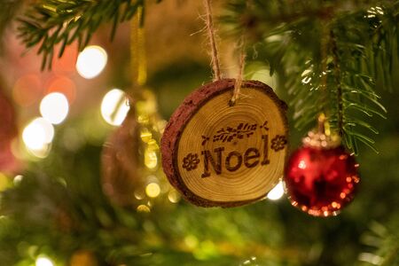A Noel log shaped Christmas Tree Decoration hanging from a treeの写真素材