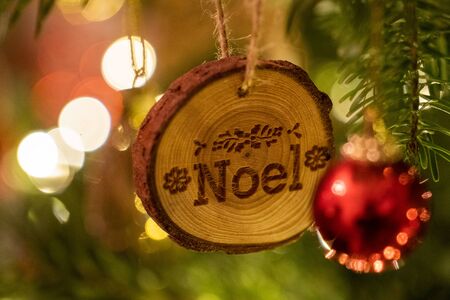 A Noel log shaped Christmas Tree Decoration hanging from a treeの写真素材