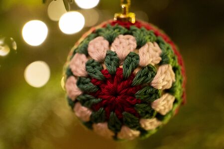 A fabric bauble shaped Christmas Tree Decoration hanging from a treeの写真素材