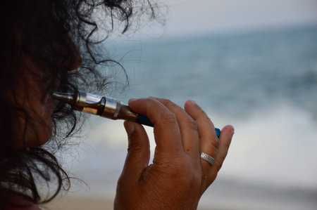 A woman on the beach with an electronic cigaretteの写真素材