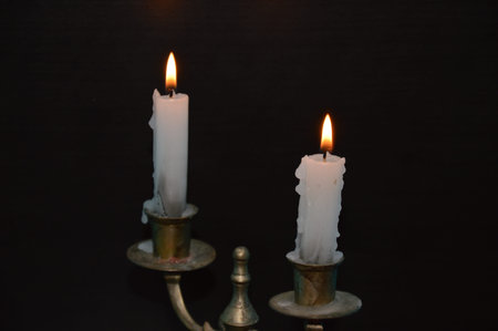White candles on a black tableの写真素材