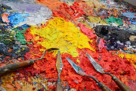 Zoom on a painter's palette in his workshop with toolsの写真素材