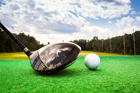 Close-up of a golf ball and a golf wood on a driving range Close-up of a golf ball and a golf wood on a driving range