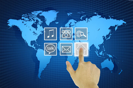 Hand Pressing House Symbol from media  icons on World Map in Computer LCD Monitor