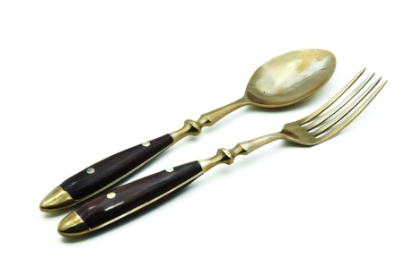 brass spoon and fork isolated on a white backgroundの写真素材
