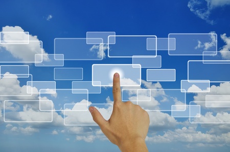 Hand pressing touchscreen button on the blue sky backgroundの写真素材