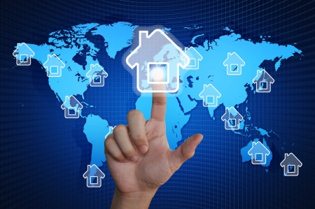 Hand pressing home symbol on world mapの写真素材
