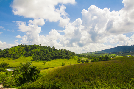 Green field and mountains with cloudy and blue sky. at Flora Park ,Wangnamkeaw - Nakhon Ratchasima , Thailand.の写真素材