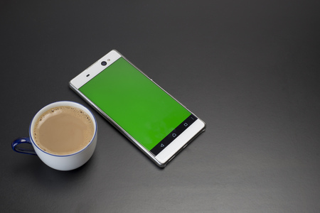 Cup of Coffee and smart phone green screenの写真素材
