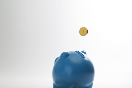 Gold coin drop to piggy bankの写真素材