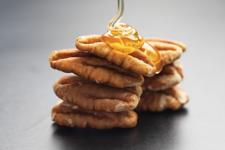 Pouring honey on Fresh Pecansの写真素材