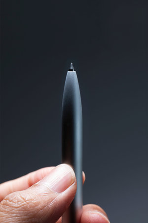 Business person holding silver ball pen