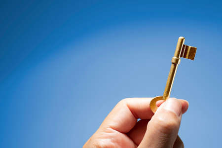 Hand holding the key to successの写真素材