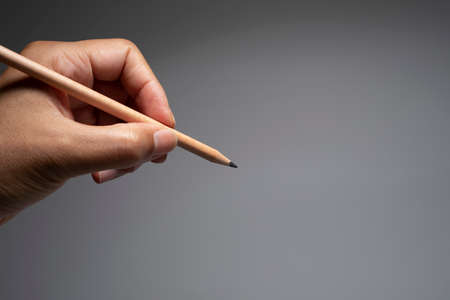 Hand holding wooden pencilの写真素材