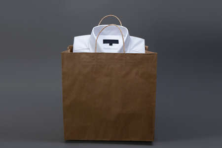 Men's shirts Folded in shopping bag, isolated on dark backgroundの写真素材