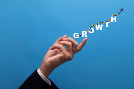 Businessman pointing arrow graph corporate future growth plan. Concept of business growth.の写真素材