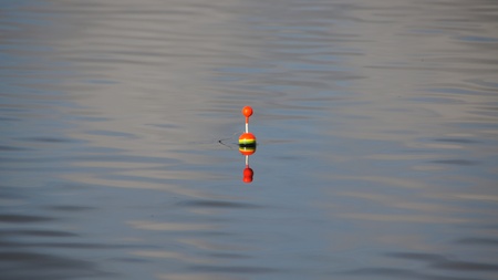 colorful anglerboje (indicators, pose) is reflected in the lakeの写真素材
