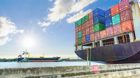 The containers cargo on the container ship in the harbor with the river and sea and cloudy sky.の写真素材