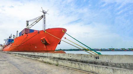 Cargo ship in the harbor with the river and sea and cloudy sky.の写真素材