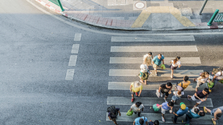 Blur people are moving across the pedestrian crosswalk in the city road (on top view)の写真素材