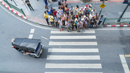 The process of blur people walking in the crosswalk business street city at the rush hour with car on the road (Aerial photo, top view)の写真素材