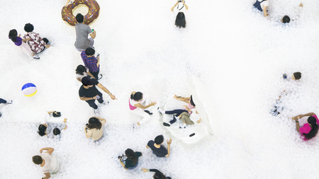 group of people play and run on the white bubble playground on the top aerial view.の写真素材