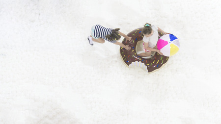 girls play and run with the ballon toy on the white bubble playground on the top aerial view.の写真素材