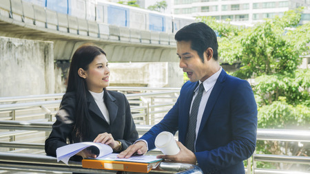 the smart business people of man and woman talk together in feeling aggressive and angry at the outdoor pedestrian walkway space in the morning.の写真素材