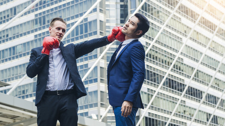 two business mans are fighting with boxing glove at outdoor cityの写真素材